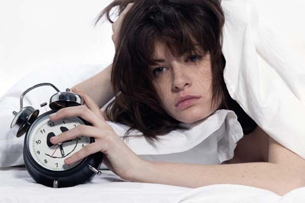 Como dormir bem Mulher acordando com despertador