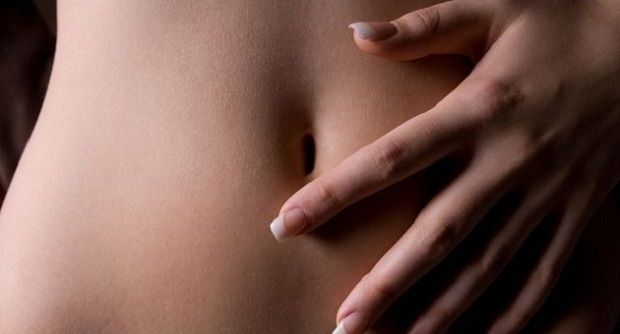 Câncer de ovário Mulher com a mão no abdômen