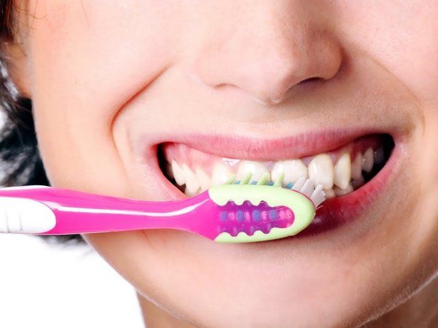 Escovando os dentes com escova rosa Gengivite