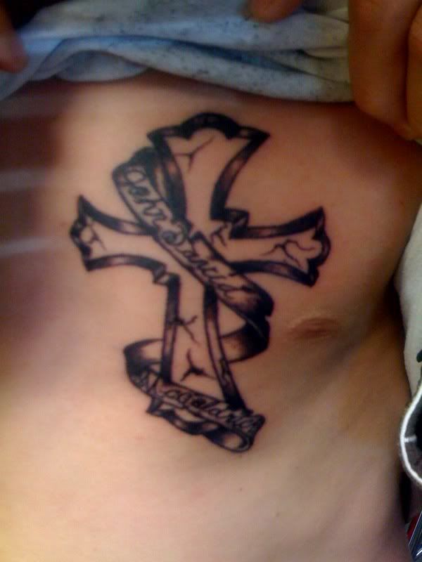 cross tattoo with ribbon. It's a tombstone in the shape of a cross with a ribbon running around that